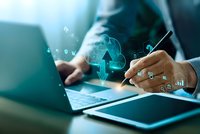 Businessman using laptop with cloud computing technology icons and data analytics symbols for digital transformation and business intelligence solutions.