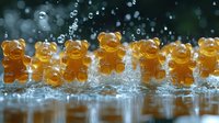 Gummy bears in row splashing in water droplets with dramatic lighting and reflection on wet surface, sweet candy motion photography for advertising.