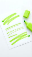 Bright neon green highlighter marker with various stroke marks and lines on white paper, isolated on white background for design and creative projects.
