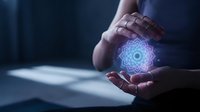 Professional businessman holding glowing blue mandala energy symbol between hands in modern office environment for spiritual technology concepts.