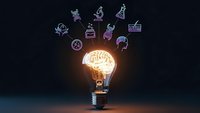 Glowing light bulb with brain filament surrounded by floating purple science icons on dark background representing innovation and creative thinking.