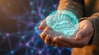Businessman holding glowing digital brain hologram in cupped hands representing artificial intelligence, innovation and mental health technology solutions.