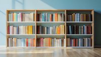 Wooden bookshelf with colorful books against light blue wall in minimalist interior. Natural sunlight casting shadows creates serene reading atmosphere.