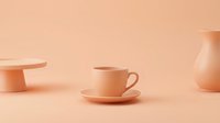 Monochromatic peach ceramic tableware set featuring a teacup with saucer, pedestal cake stand, and pitcher on matching background for home decor and lifestyle design projects.