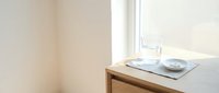 Minimalist wooden table with white ceramic bowls near bright window in modern interior design for home decor and lifestyle photography.