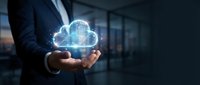 Businessman holding glowing digital cloud computing technology hologram in modern office environment for data storage and network connectivity solutions.