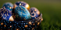 Festive blue and gold ornamental eggs with glitter patterns nestled in decorative nest against green background, creating magical holiday atmosphere.