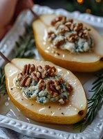 Roasted pear halves stuffed with blue cheese and chopped walnuts, drizzled with honey on white plate with rosemary garnish for gourmet appetizer recipes.