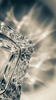 Crystal clear glass pitcher with intricate cut patterns and decorative details showcasing elegant tableware craftsmanship for dining and beverage service.