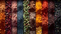 Vibrant rows of colorful ground spices and seasonings create striking pattern. Aromatic ingredients include turmeric, paprika, cardamom pods, and peppercorns.