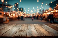 Rustic wooden table with blurred night market or street festival background, string lights creating festive bokeh atmosphere.