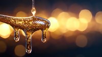 Golden honey drips in sunlight with water drops falling, creating magical bokeh effect in background. Natural organic sweetener macro photography.