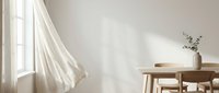 Bright minimalist interior with sheer white curtains flowing from window, wooden table, chair, and vase with dried flowers on neutral wall background for home decor and design projects.