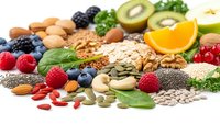 Healthy superfood selection with nuts, seeds, berries and fruits on white background for balanced nutrition and wellness lifestyle.
