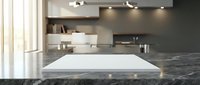 Modern kitchen interior with empty white cutting board on dark marble countertop, floating shelves, track lighting and natural window light for food preparation.