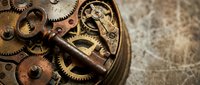 Vintage clockwork mechanism with brass gears and copper components on textured surface. Antique timepiece parts for steampunk designs and mechanical concepts.