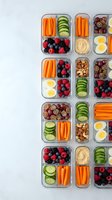 Healthy meal prep containers with fresh vegetables, fruits, nuts and eggs arranged in organized compartments for weekly nutrition planning and diet goals.