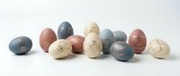 Modern minimalist Easter eggs in muted pastel colors with geometric line patterns scattered on white background for spring holiday decoration.