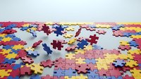 Colorful jigsaw puzzle pieces scattered on white surface with completed sections showing vibrant pink blue yellow pattern for problem solving concepts.