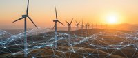 Wind turbines generating renewable energy at sunset with digital network connections overlay representing smart grid technology and sustainable power infrastructure.