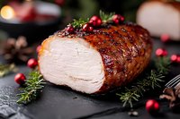 Sliced roasted turkey breast with cranberries and rosemary herbs on dark stone background, glazed with honey marinade, festive holiday main dish preparation.