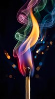 Colorful smoke rising from burning matchstick with vibrant rainbow flames against dark background with glowing bokeh lights for creative design projects.
