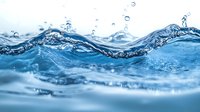 Dynamic blue water wave with splashing droplets and ripples creating natural flowing motion against light background, macro photography for freshness concept.