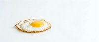 Fried egg with golden yolk isolated on white background for breakfast menu design and culinary projects.