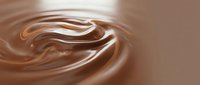 Smooth chocolate liquid swirls and waves in motion, creating an abstract flowing pattern with glossy highlights and rich brown tones for food and beverage design.
