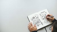 Business strategy planning concept with hand drawing growth charts, graphs and success icons in notebook on white desk for corporate development.