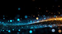Magical glowing particles with blue and gold bokeh lights on black background create atmospheric festive mood for celebration designs and backgrounds.