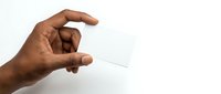 African American male hand holding blank white business card between fingers on clean white background for mockup and branding design projects.
