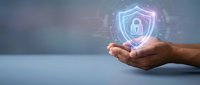Hands protecting glowing digital security shield with padlock icon representing cybersecurity, data protection and privacy technology solutions.