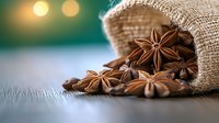 Star anise pods spilling from rustic burlap sack on wooden surface with soft bokeh lights in background, aromatic spice macro photography for culinary design.