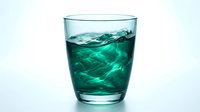 Glass of refreshing green liquid with ice cubes on white background, isolated for beverage, drink, and wellness design projects.