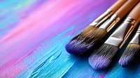 Professional makeup brushes on vibrant holographic background with blue and pink gradient colors create artistic composition for cosmetics and beauty industry.