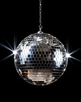 Shiny disco ball with bright light reflections hanging on chain against black background, creating classic retro party atmosphere and sparkling effects.