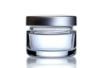 Empty glass cosmetic jar with black lid on white background with reflection, isolated luxury skincare packaging mockup for beauty product design.