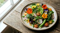 Fresh mixed greens salad with edible flowers, cherry tomatoes and radishes on rustic wooden table for healthy dining and restaurant menu concepts.