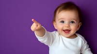 Happy baby in white long sleeve shirt pointing and laughing against purple background, expressing joy and curiosity. Bright natural lighting highlights cheerful expression.