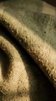 Close-up of weathered stone sculpture showing detailed texture and erosion patterns in warm natural lighting for artistic and historical projects.