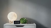 Modern bedroom nightstand with glowing moon lamp, digital clock, succulent plant and eyeglasses creating cozy evening ambiance for home decor and interior design.