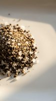 Crushed black peppercorns spice blend scattered on white surface with warm lighting for culinary cooking and seasoning applications.