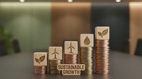 Stacked coins with wooden blocks featuring sustainability icons and sustainable growth text, representing eco-friendly business investment and financial progress.