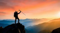 Silhouette of triumphant hiker with trekking pole celebrating success on mountain peak at golden sunrise with layered mountain ranges in background.