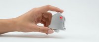 Hand holding white computer mouse with red button on clean background for technology and office design concepts.