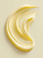 Smooth yellow cream swirl texture on beige background, cosmetic moisturizer or skincare product sample showing rich creamy consistency and glossy finish.