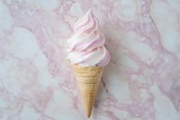 Soft serve pink strawberry ice cream in waffle cone on pink marble background, perfect for food marketing and dessert menus.