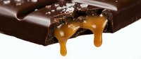 Dark chocolate bar with caramel dripping, isolated on white background. Suitable for food advertising, confectionery packaging, and dessert marketing materials.
