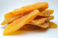 Sweet dried mango slices stacked together showing natural texture and vibrant orange color, perfect for healthy snacking and food photography backgrounds.